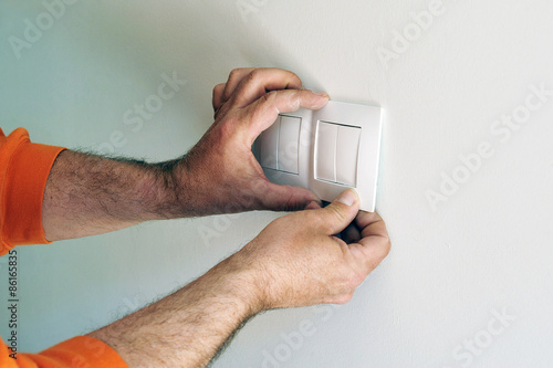 Fotografie Electricista instalando los interruptores eléctricos durante la reforma de una c