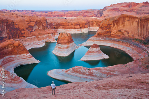A hiker overlooking Reflection Canyon at the sunset, Glen Canyon National Recreation,  Utah, United States photo