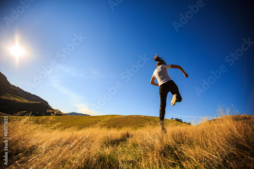 young adult woman running on meadow
