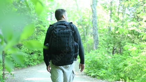 Man hiking green forest trail