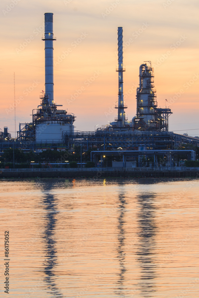 Petrochemical plant at sunrise with reflection on water