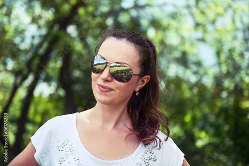 Young woman in sportswear standing outdoors in a park on sunny s