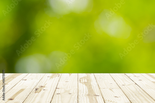Wood table top on green blurry backgrounds.