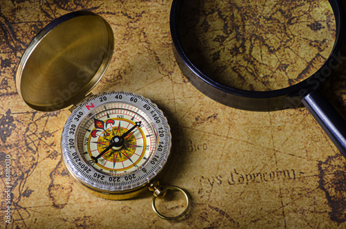 Compass and magnifying glass on old map