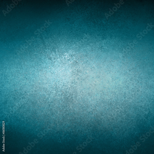 blue background textured painted wall with black shadows on border and bright shiny center with blank copyspace for adding your own text or image