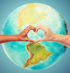 human hands showing heart shape over earth globe