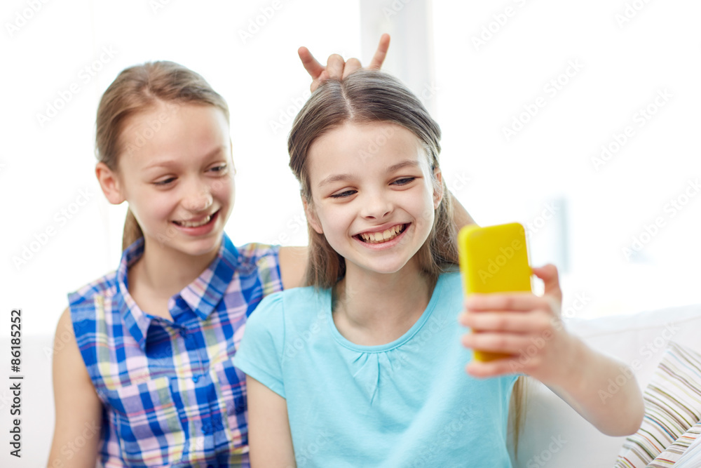 happy girls with smartphone taking selfie at home happy girls with smartphone taking selfie at home