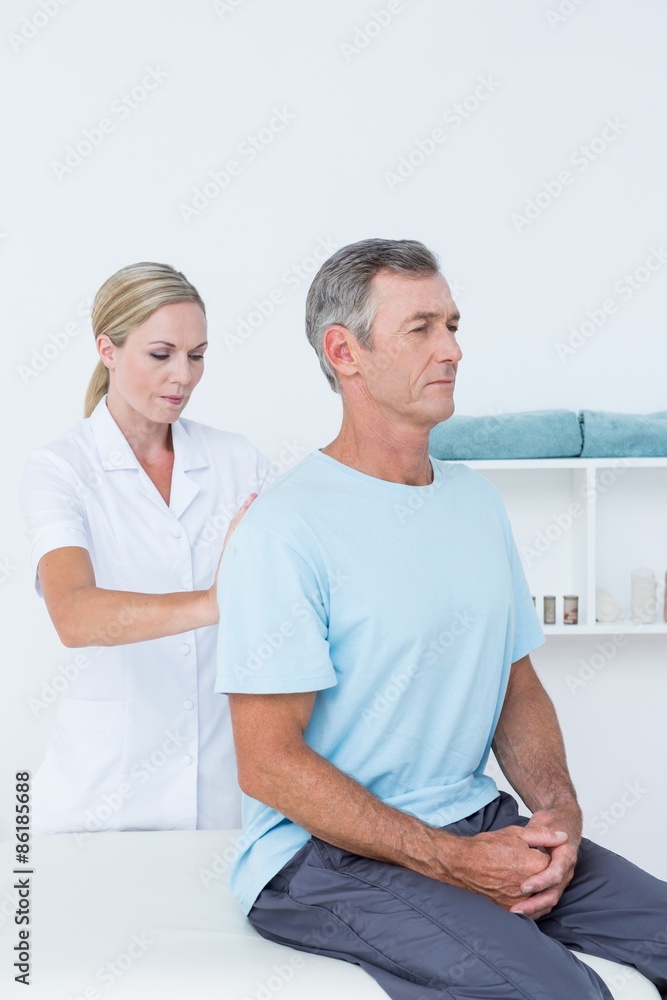 Obraz premium Doctor examining her patient back 
