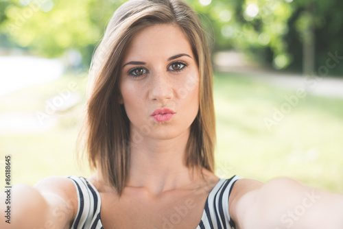 Beautiful young woman making selfie and grimacing