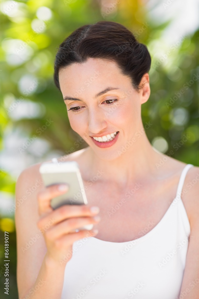 woman in white looking at her phone woman in white looking at her phone