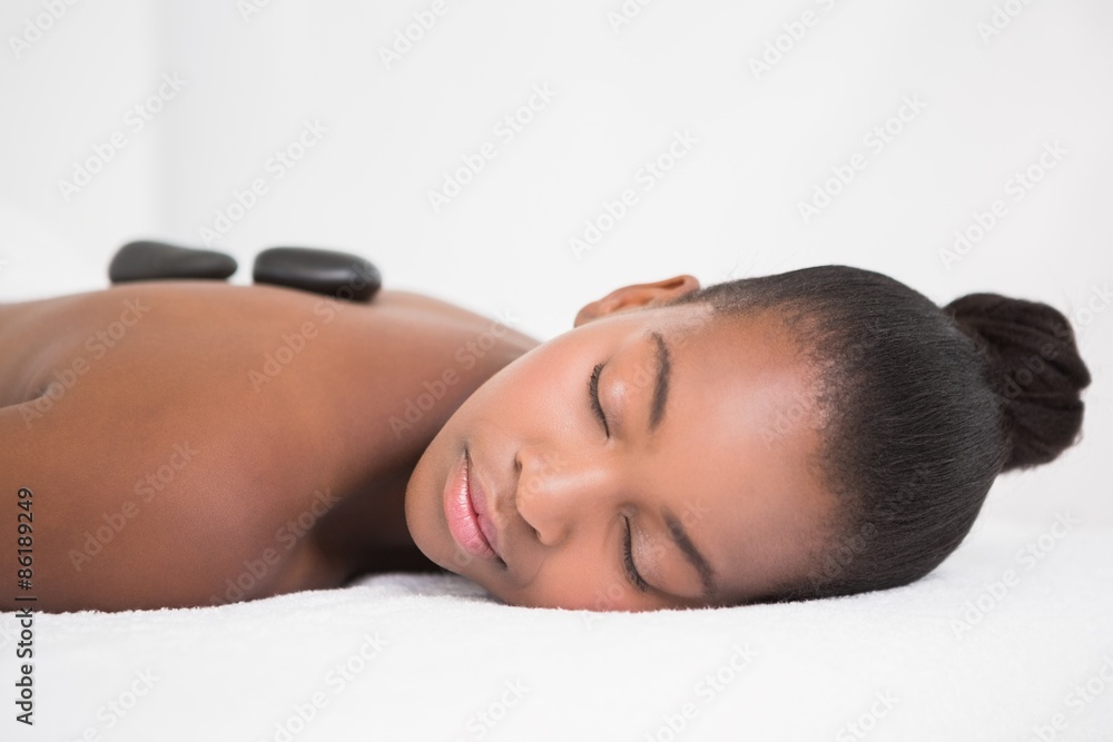 Obraz premium Pretty woman enjoying a hot stone massage