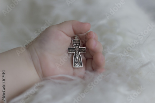 Christian cross in the hand of the child