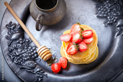 Stack of sweet pancakes with strawberry and honey. photo