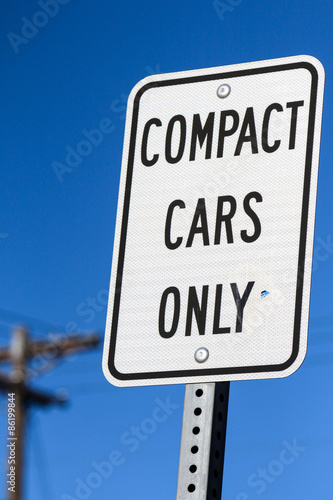 Simple black and white rectangular sign that says "Compact Cars Only"