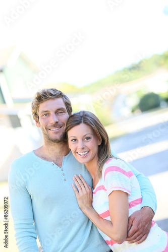 Portrait of cheerful couple standing in new property walkway