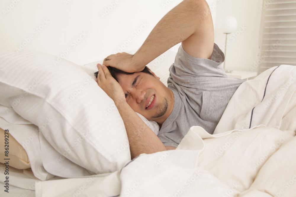 Man waking up with headache Man waking up with headache