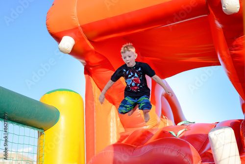 Small boy having fun on a jumping castle