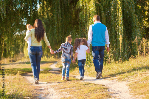 Big family walking in city park.