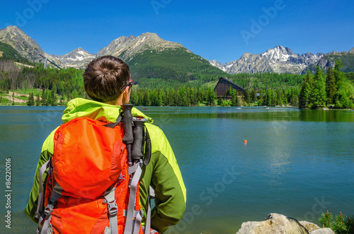 Young man admires high mountains and lake Slovakia