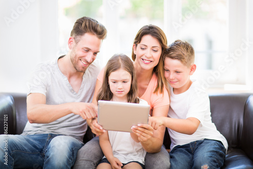 фотографія Familie zu hause benutzt tablet pc auf der Couch