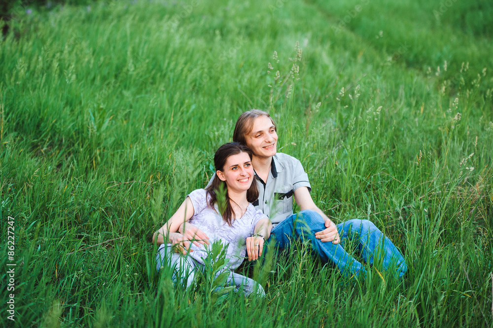 Fototapeta premium Couple in love on meadow on green grass