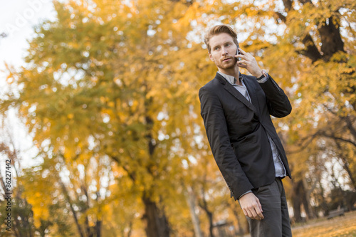 Young man with mobile phone in the autumn park © BGStock72