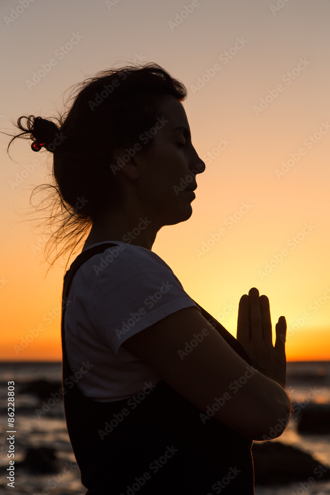 Silhouette young woman practicing yoga on the beach at sunset. Silhouette young woman practicing yoga on the beach at sunset.