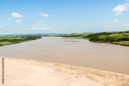Aerial flying low front of river mouth beach farming landscape