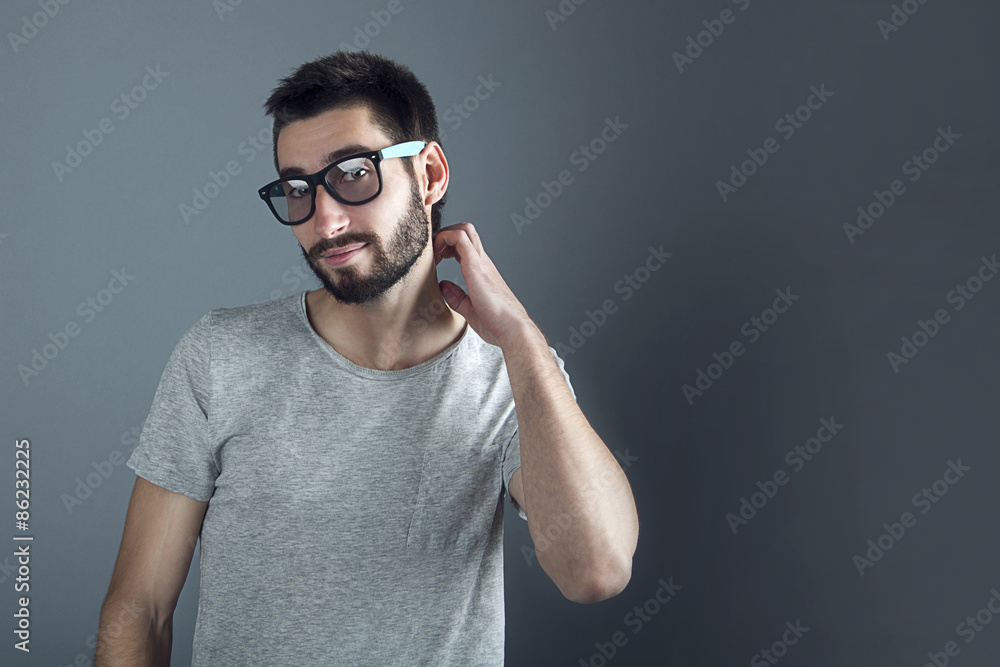 man with beard dressed casual smiling against gray wall man with beard dressed casual smiling against gray wall