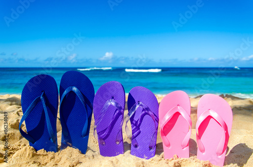 Colorful flip flops on the sandy beach