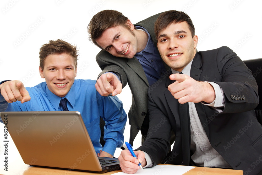Three young smiling business people shows on you
Three young smiling business people shows on you