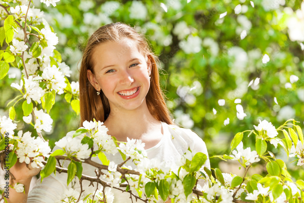 Happy teenager girl with white flowers on tree Happy teenager girl with white flowers on tree