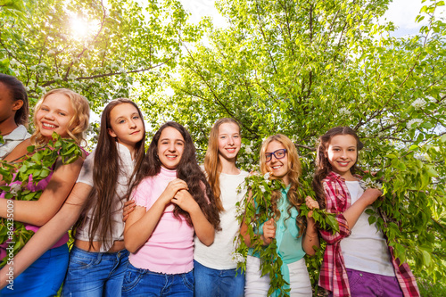 Smiling teenage girls standing and holding benches © Sergey Novikov