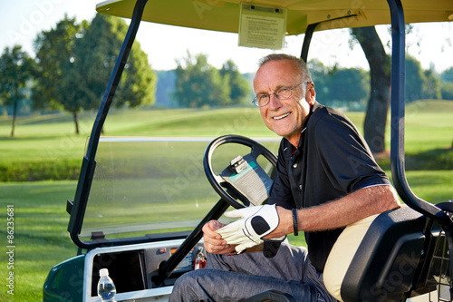 Senior golfer sitting in a golfcart photo