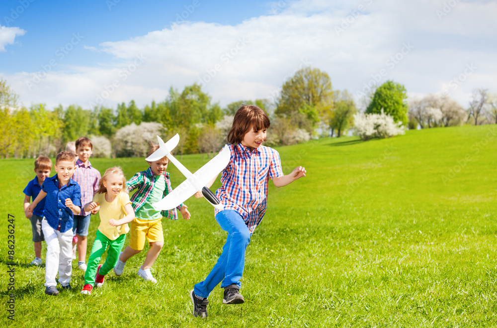 Happy running children with big white airplane toy Happy running children with big white airplane toy