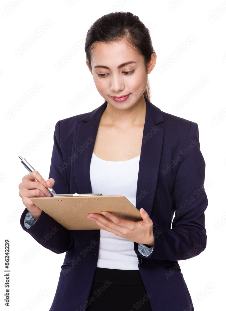 Asian businesswoman write on clipboard Asian businesswoman write on clipboard