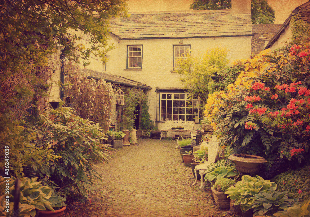 Garden at the front of  old house, Lake District, Cumbria, UK.  Photo in retro style.  Added paper texture.