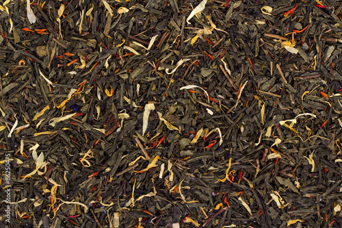 background of black tea leaves. View from above.