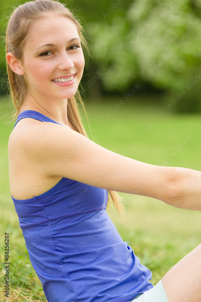 Junge Frau in Sportsachen lächelt zufrieden