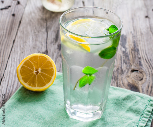lemonade with ice, lemon slices and fresh mint in a glass