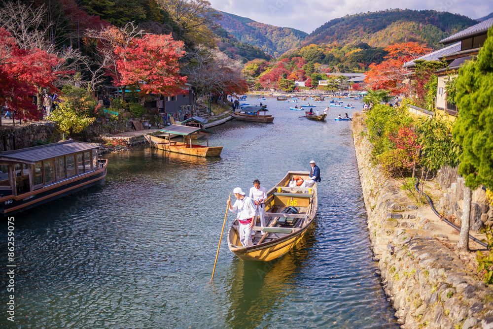 people sail boates in the river at arashiyama