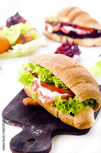 Croissant sandwich with salted salmon on plate,