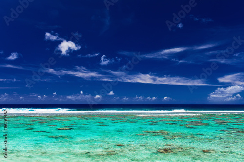 Blue sky and surf beach on a coral reef, tropical island