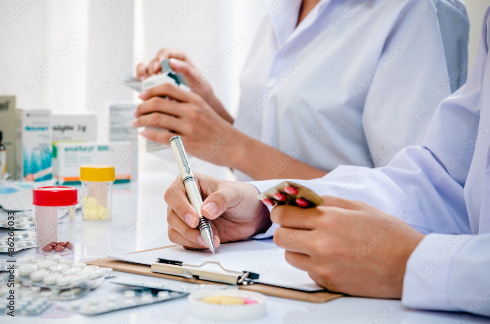 two pharmacists preparing prescription and medicine box two pharmacists preparing prescription and medicine box