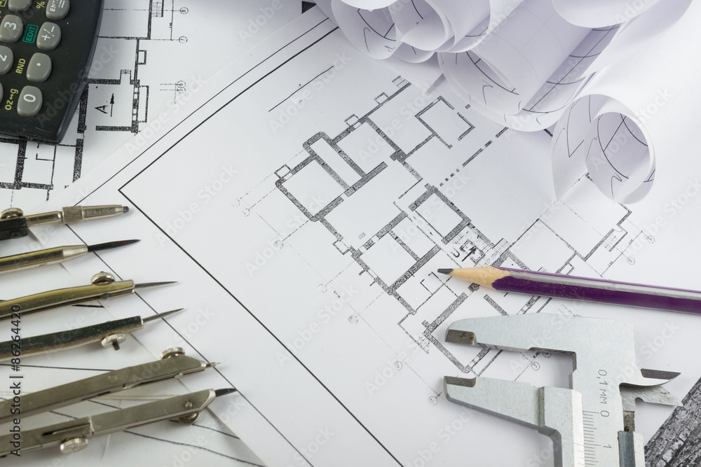 Architectural project, blueprints, blueprint rolls and divider compass, calipers, folding ruler on plans Engineering tools view from the top. Copy space. Construction background. Architectural project, blueprints, blueprint rolls and divider compass, calipers, folding ruler on plans Engineering tools view from the top. Copy space. Construction background.