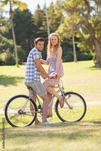 Young couple on a bike ride looking at camera