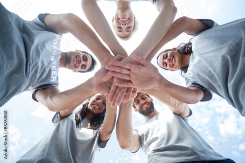Фотография Happy volunteers putting their hands together