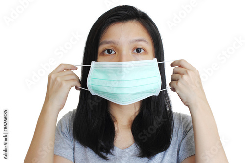 Portrait of Asian woman putting on medical mask on white background.