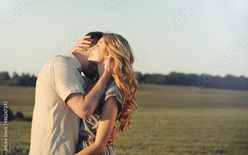 stunning sensual young couple in love embracing at the sunset