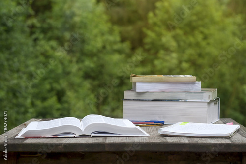 summer homework, books and notebook on a garden wooden table photo